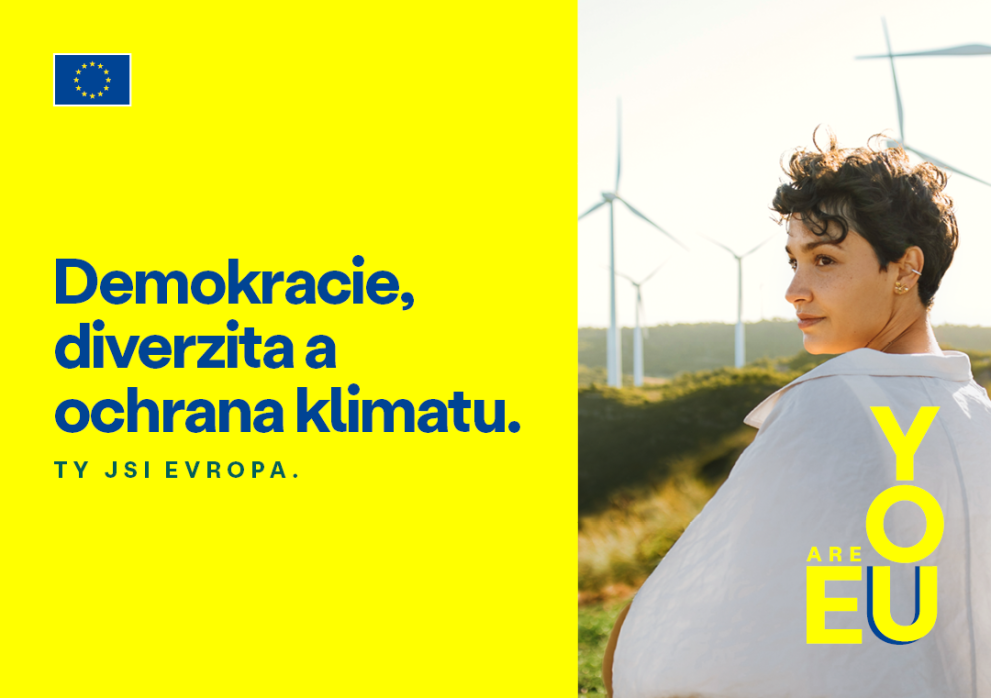 Demokracie, diverzita a ochrana klimatu - mladá žena, v pozadí několik větrných turbín 