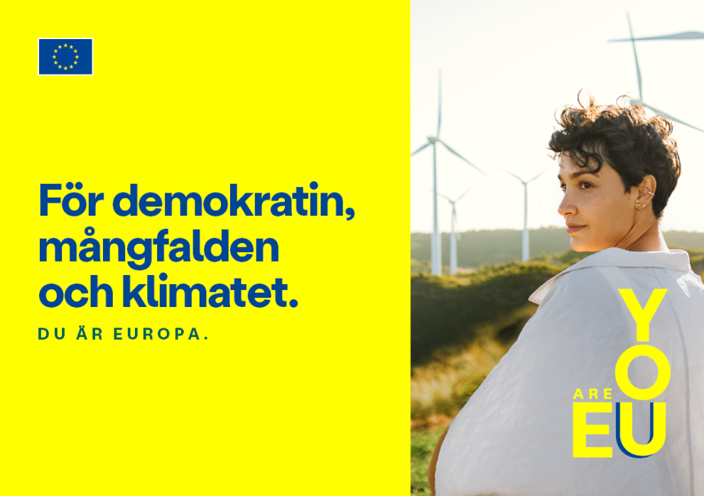 För demokratin, mångfalden och klimatet - En ung kvinna som står med flera vindkraftverk i bakgrunden